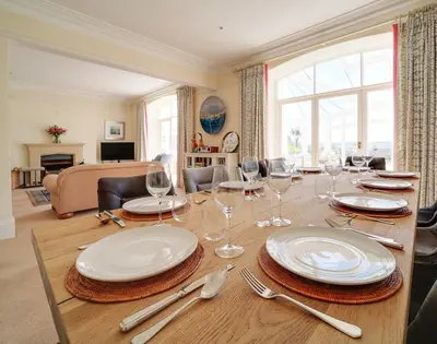 a dining table with plates and wine glasses on it at The Haven in Polzeath