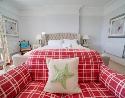 a bedroom with a bed and a couch with a starfish pillow at The Haven in Polzeath