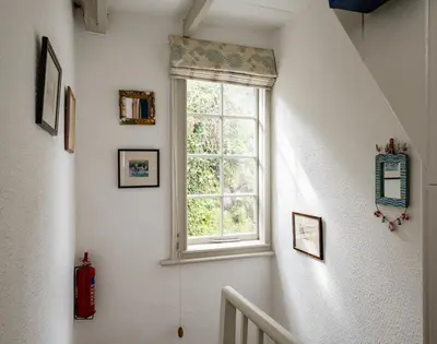 a staircase with a window in a room at April Cottage in Port Isaac