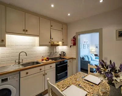 a kitchen with a sink and a table with a counter top at April Cottage in Port Isaac