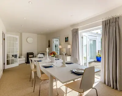 a dining room with a white table and chairs at The Moorings in Padstow