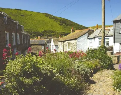 a small town with houses and flowers on a hill at Kipper Cottage in Port Isaac