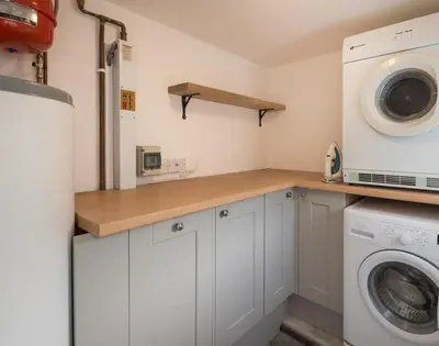 a kitchen with a washing machine and a washer at Kipper Cottage in Port Isaac