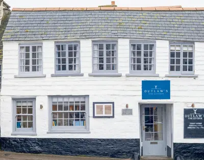 a white building with a blue sign in front of it at Kipper Cottage in Port Isaac