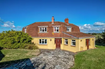 a large yellow house with a brick roof at Trevan House Lundy in Polzeath