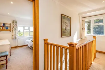 a room with a staircase and a mirror at Trevan House Lundy in Polzeath