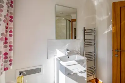a white bathroom with a sink and a mirror at Trevan House Lundy in Polzeath