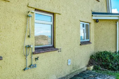 a shower on the side of a building with a window at Trevan House Lundy in Polzeath