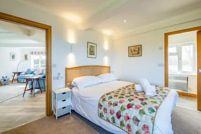 a bedroom with a bed and a desk in a room at Trevan House Lundy in Polzeath