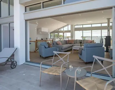 a living room with two blue couches and a table at Point Break in Polzeath