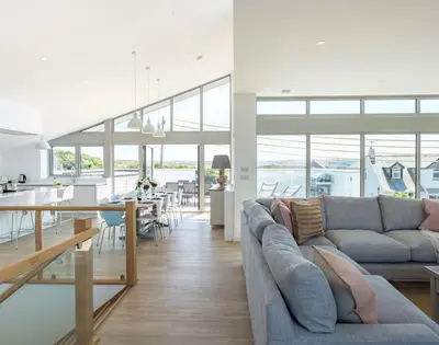 a living room and kitchen with a couch and a table at Point Break in Polzeath