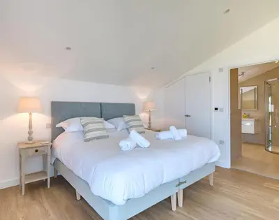 a bedroom with a large white bed with pillows at Point Break in Polzeath