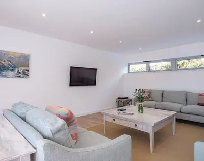a living room with a couch and a table at Point Break in Polzeath