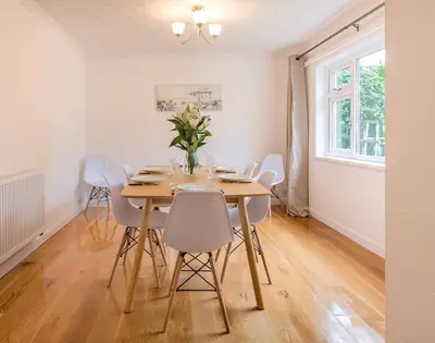 a dining room with a wooden table and chairs at Greenaway, 4 Rockhaven Gardens in Saint Minver