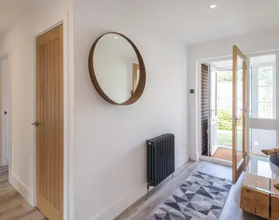 a living room with a mirror on the wall at Greenaway, 4 Rockhaven Gardens in Saint Minver