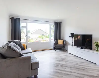 a living room with a couch and a tv at Greenaway, 4 Rockhaven Gardens in Saint Minver
