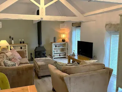 a living room with two couches and a fireplace at Lavender Barn in Newquay