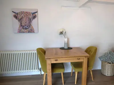 a dining room table with a picture of a cow at Lavender Barn in Newquay