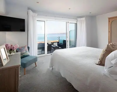a bedroom with a bed and a view of the ocean at The Crows Nest in Port Isaac