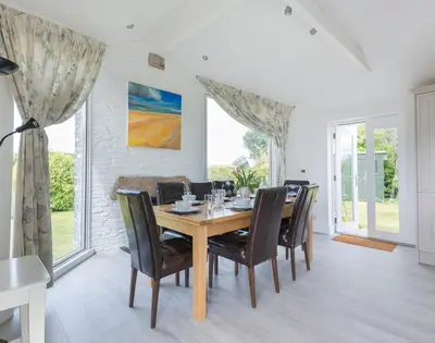 a dining room with a wooden table and chairs at Penny Liggan in Padstow