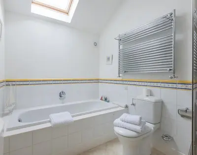 a white bathroom with a tub and a toilet at Penny Liggan in Padstow
