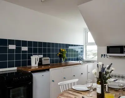 a kitchen with a table and a counter top at Pinewood 14 in Polzeath
