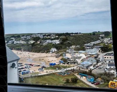 a view of a beach from a window at Pinewood 14 in Polzeath