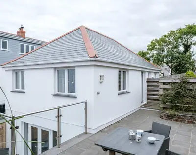 a white house with a patio and a table at The Hideaway in Port Isaac