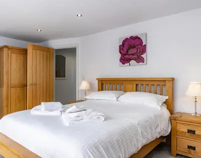 a bedroom with a large white bed with towels on it at The Hideaway in Port Isaac