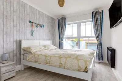 a bedroom with a white bed and a window at Number 28 in Port Isaac