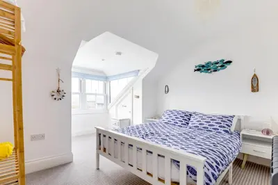 a white bedroom with a bed and a desk at Number 28 in Port Isaac