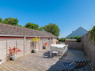 a wooden deck with a table and chairs on it at Number 28 in Port Isaac
