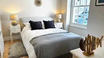 a bedroom with a large bed and a window at 1 Tintagel in Port Isaac