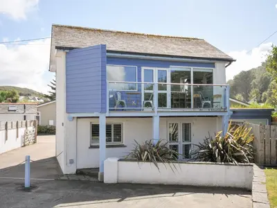 a blue and white house with a balcony at Beachside in Polzeath
