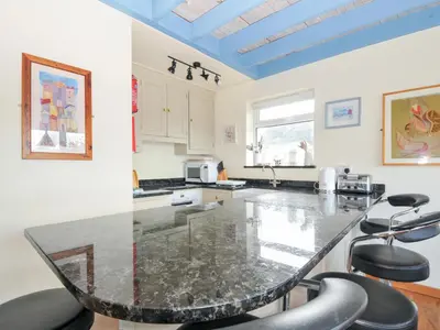 a kitchen with a large marble table and chairs at Beachside in Polzeath