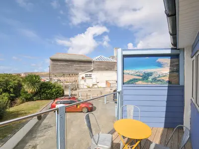 a balcony with a table and a car on it at Beachside in Polzeath