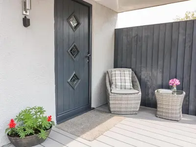 a porch with a blue door and a wicker chair at Westfields in Launceston