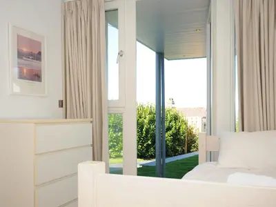 a bedroom with a bed and a large window at Drishti in Polzeath
