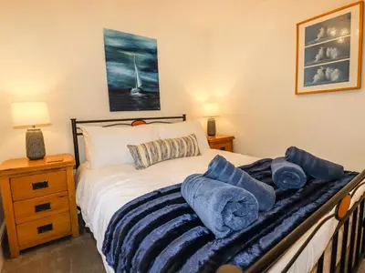 a bedroom with a bed with blue towels on it at Ludgvan Cottage in Gorran Haven