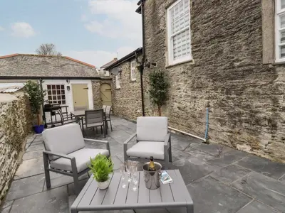 a patio with two chairs and a table at Ludgvan Cottage in Gorran Haven