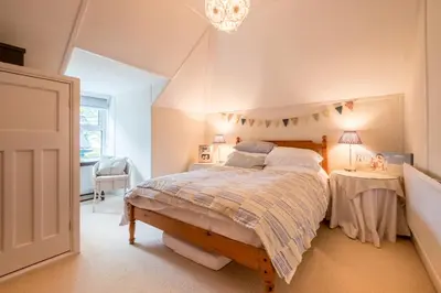 a bedroom with a bed and a table at Sandy Lodge Rock in Padstow