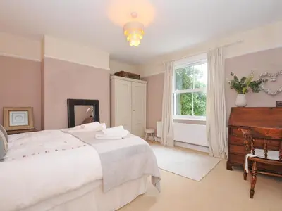 a bedroom with a white bed and a piano at Sandy Lodge Rock in Padstow