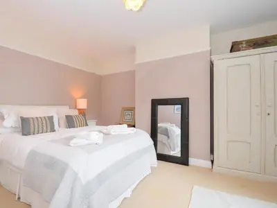 a bedroom with two white beds and a mirror at Sandy Lodge Rock in Padstow