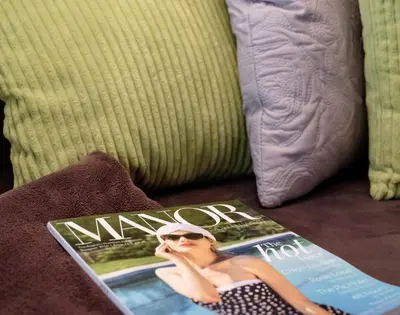 a magazine sitting on a couch with a woman on it at St Martins Apartment in Saint Minver