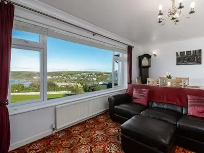 a living room with a couch and a large window at Hillview in Wadebridge
