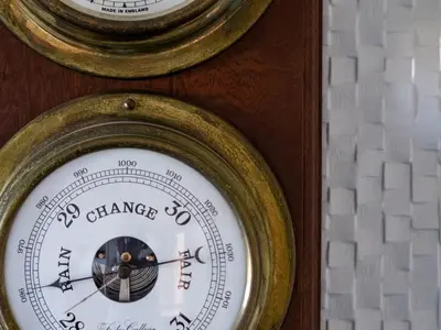 two gold clocks on a wall with a gauge at Hillview in Wadebridge