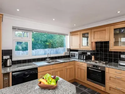 a kitchen with wooden cabinets and a bowl of fruit on a counter at Hillview in Wadebridge