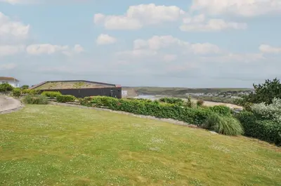 a grassy yard with a building in the background at Hillview in Wadebridge