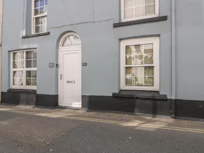 a white door on the side of a building at Blue Crab Cottage in St Austell