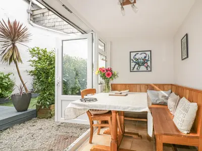 a dining room with a table and a window at Blue Crab Cottage in St Austell